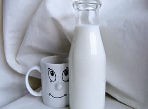 botella de leche entera junto a vaso